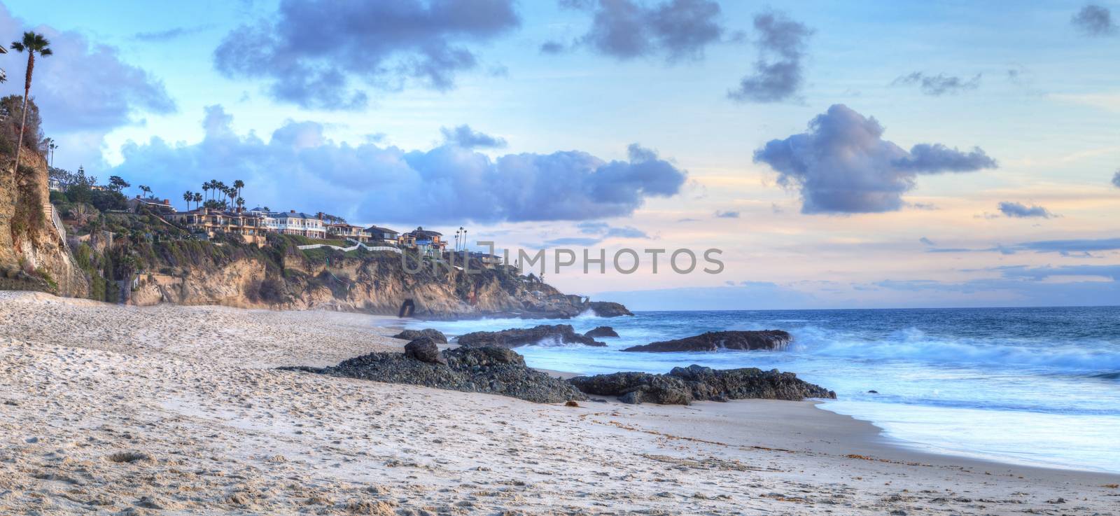 Sunset over the coastline of One Thousand Steps Beach with tidal pools and cliffs in Laguna Beach, California, USA