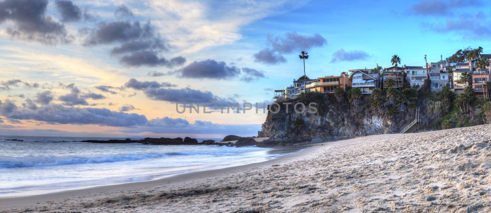 Sunset over the coastline of One Thousand Steps Beach with tidal pools and cliffs in Laguna Beach, California, USA