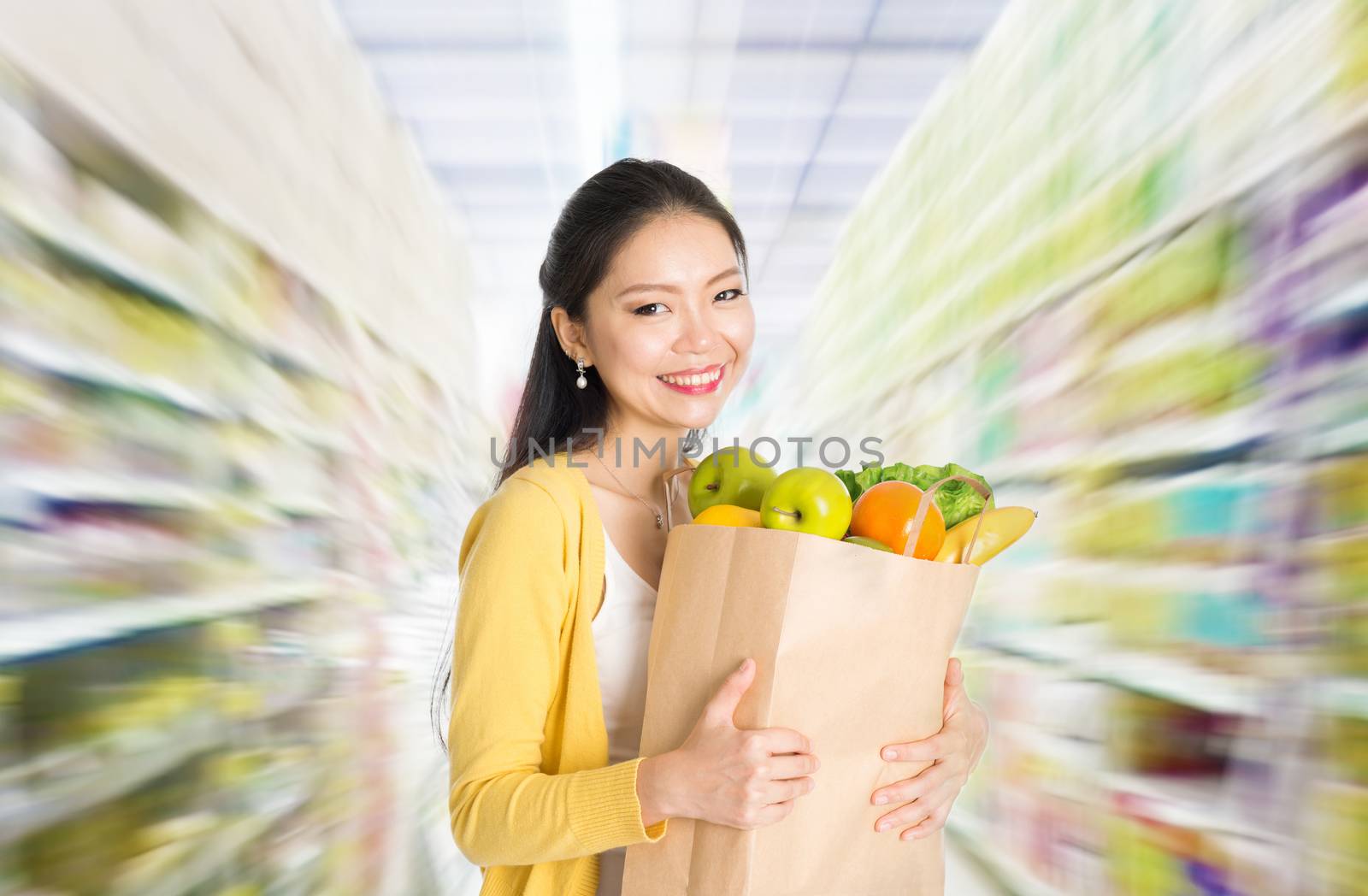 Young Asian woman hand holding shopping paper bag filled with fruits and vegetables in market or department store. 