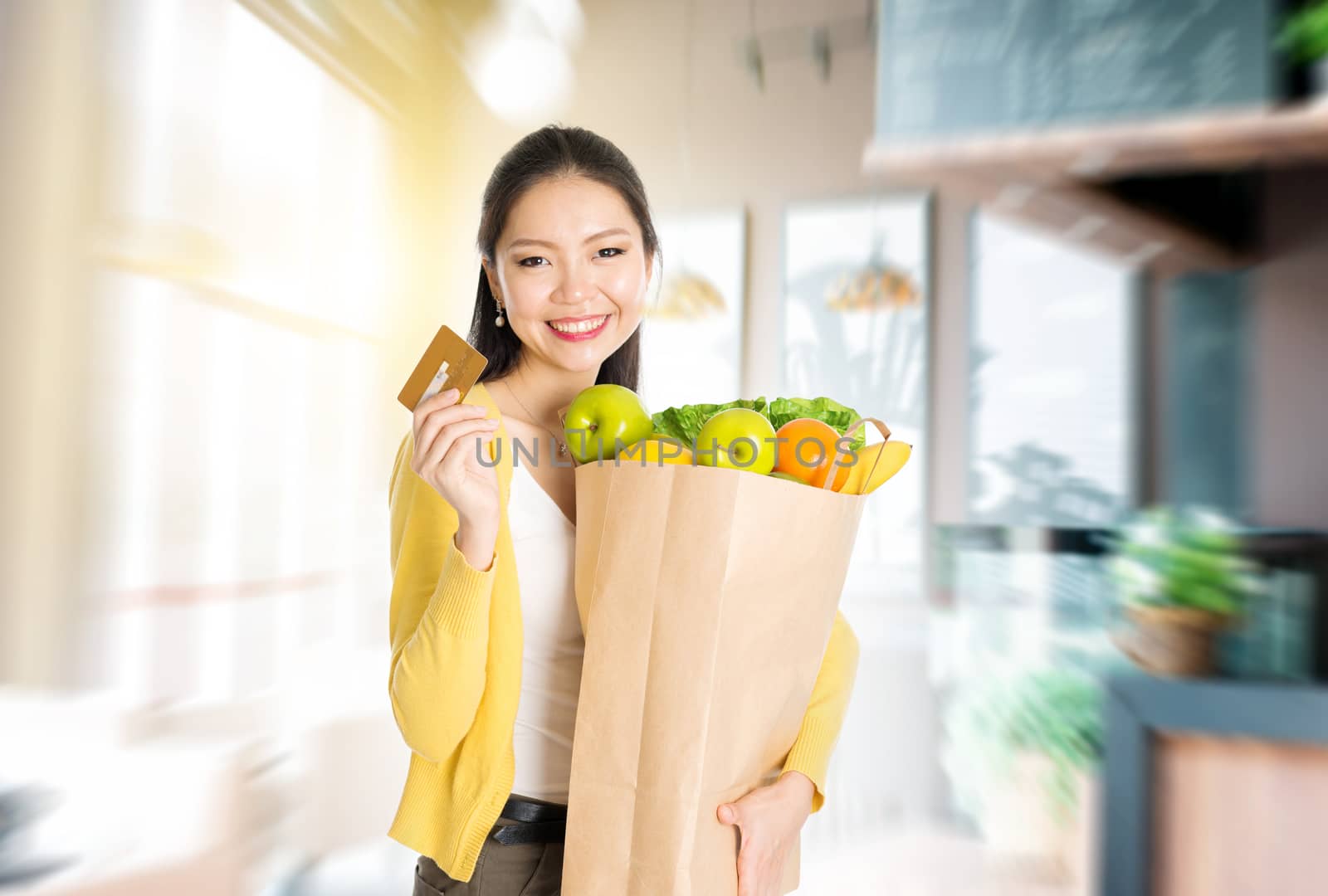 Asian woman holding groceries bag and credit card in market by szefei