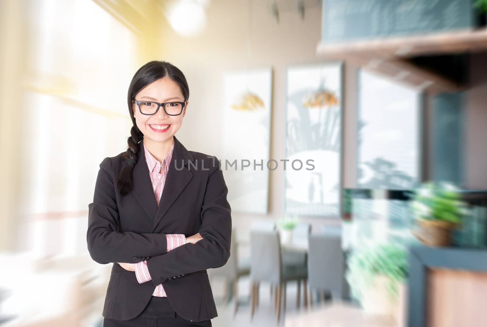 Young Asian businesswoman arms crossed standing in her chain cafe. Female entrepreneur or shop owner.