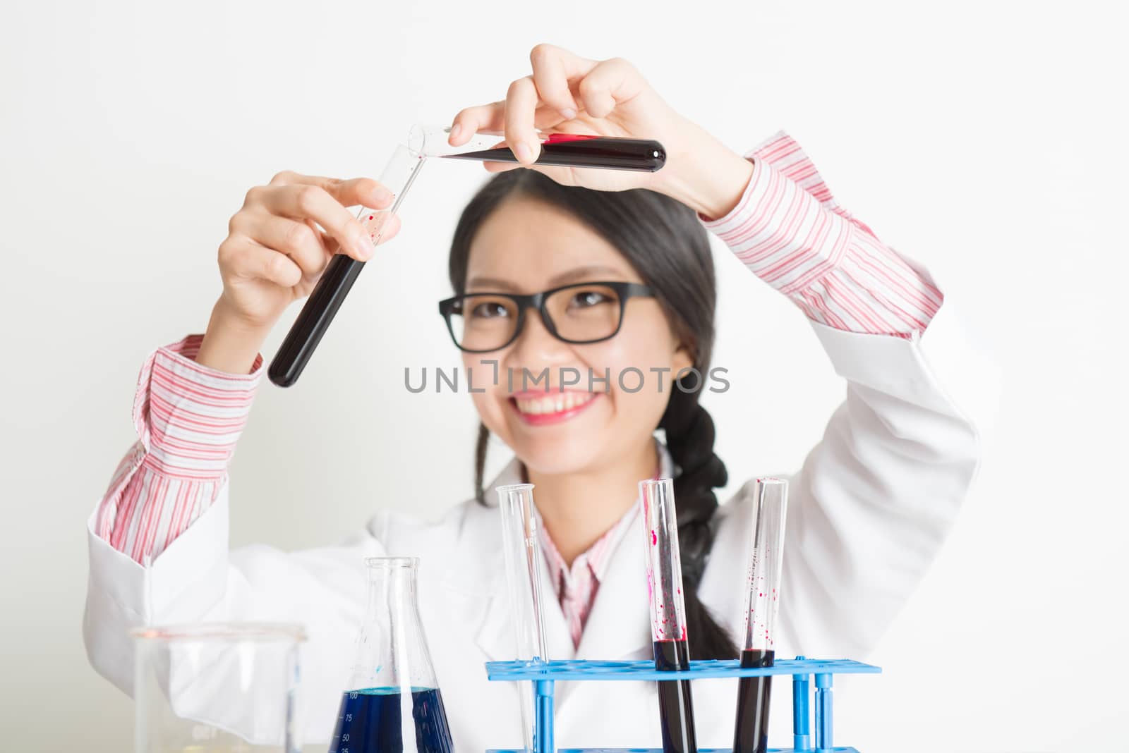 Young Asian Chinese laboratory assistant checking the blood in tube, portrait shot of a female scientist.