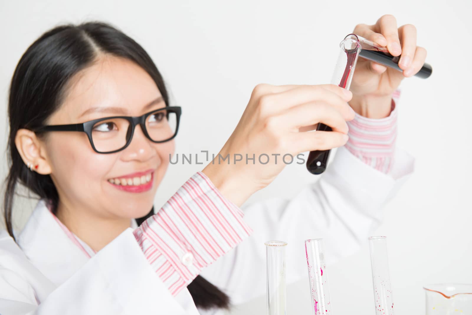 Attractive Asian female researcher carrying out scientific research in a lab.