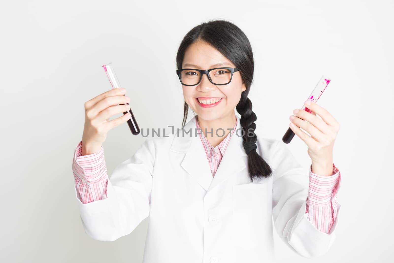 Young Asian female scientist checking the blood in tube.