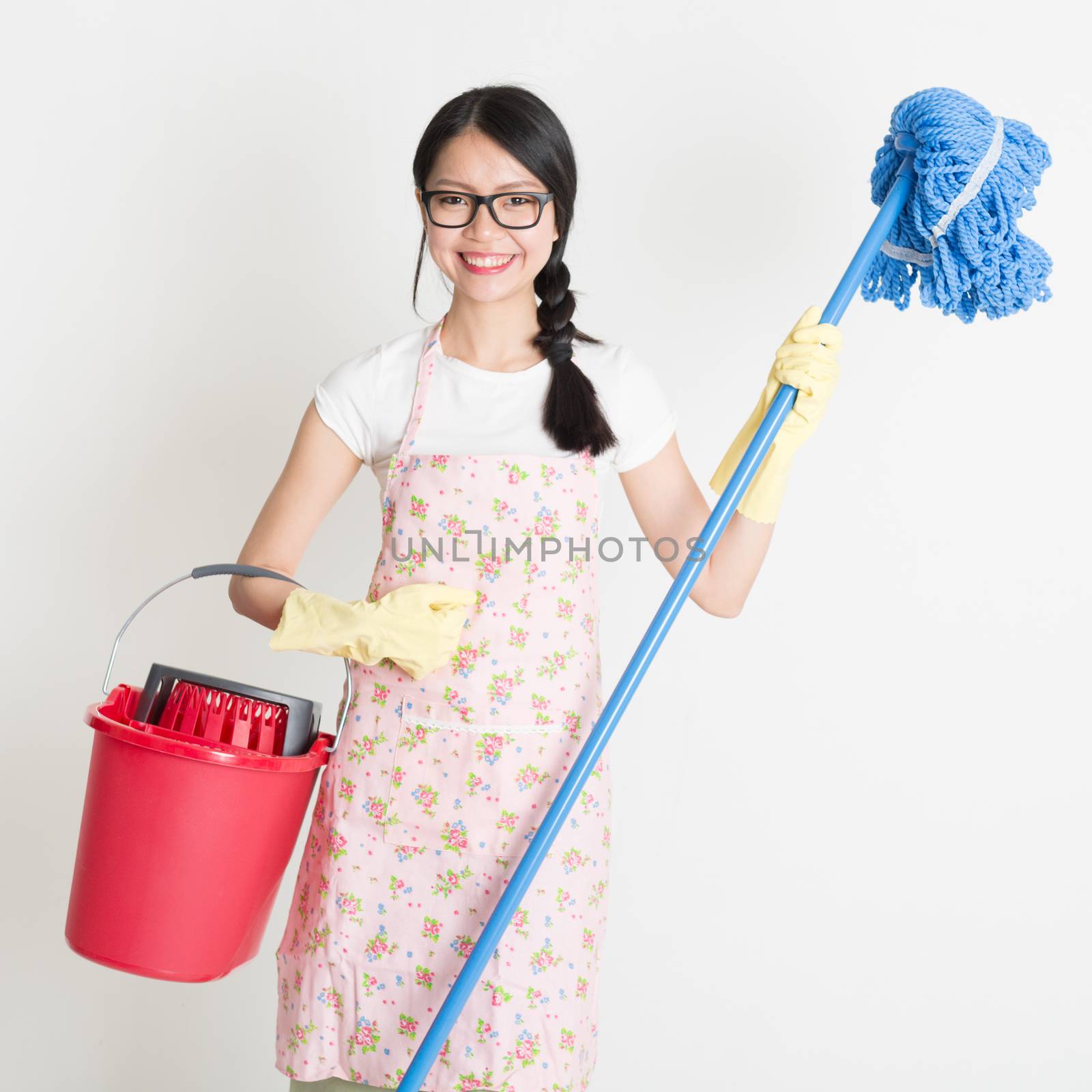 Young Asian housewife hand holding bucket and mop, doing house chores.