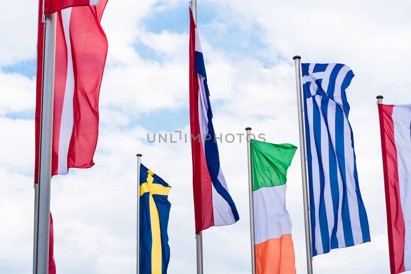 Several Europe countries flags arranged in front of a blue sky.