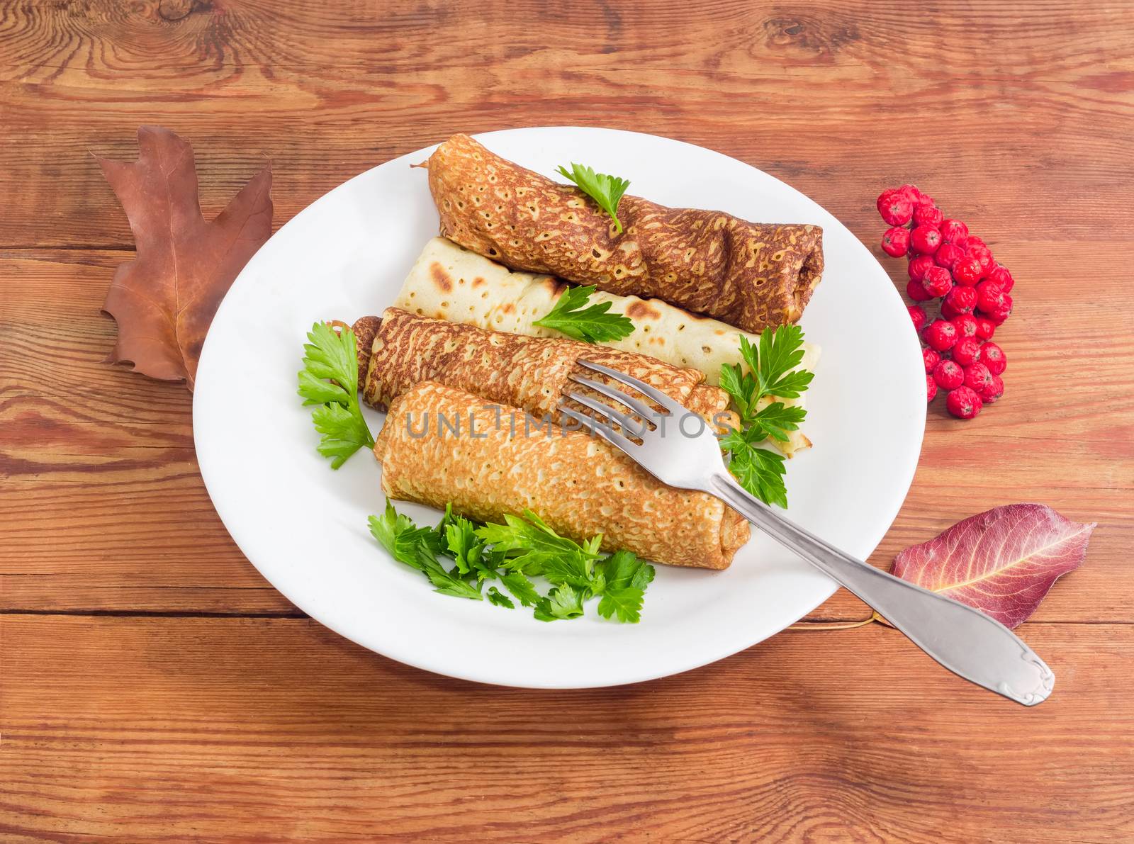 Pancakes filled with meat stuffing on white dish and fork