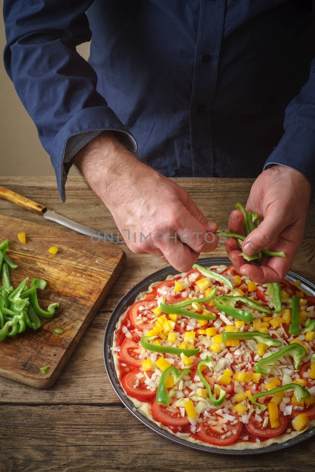 Man makes homemade pizza on the table by Deniskarpenkov