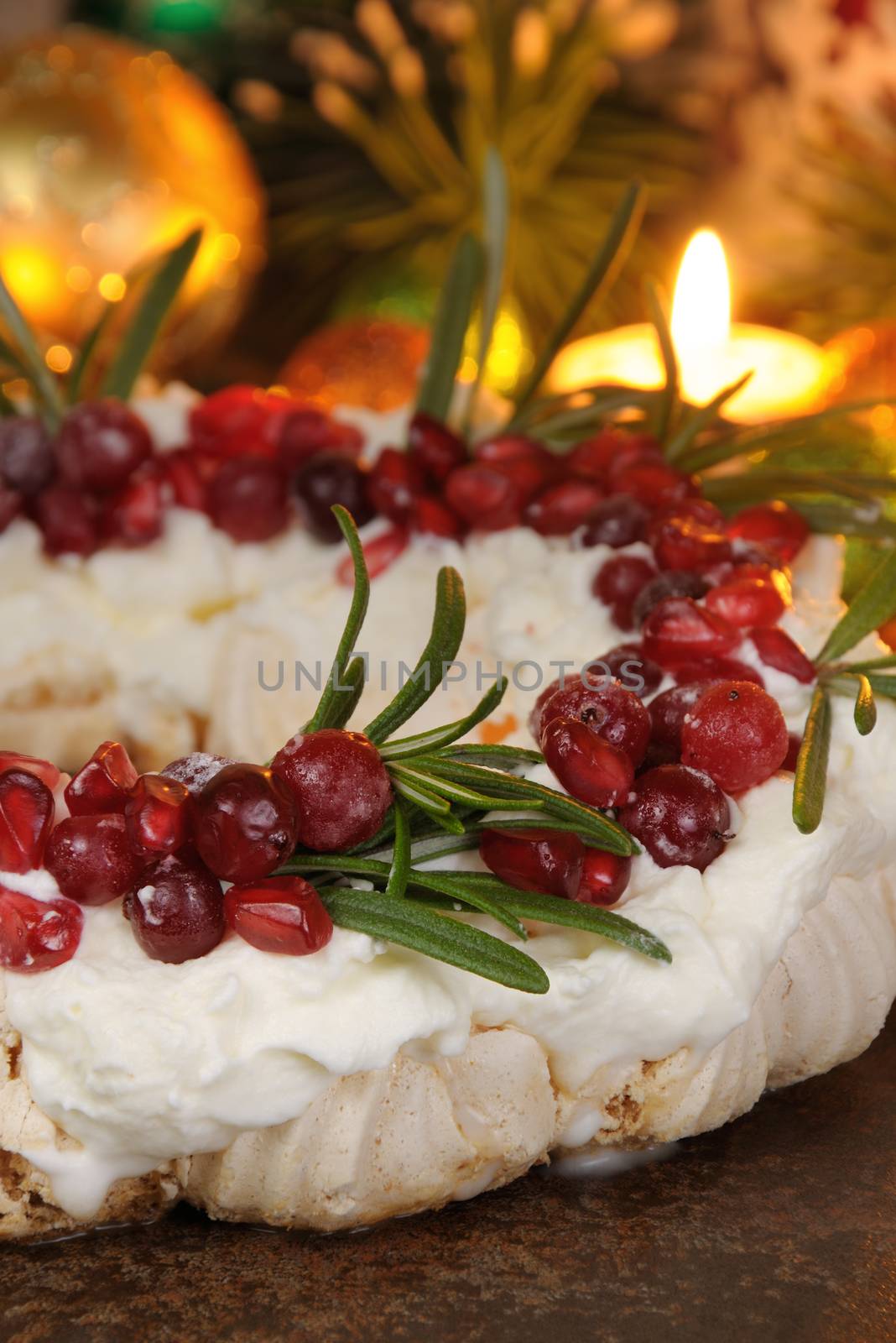 Christmas wreath made of meringue with cream, pomegranate, cranberry, rosemary closeup