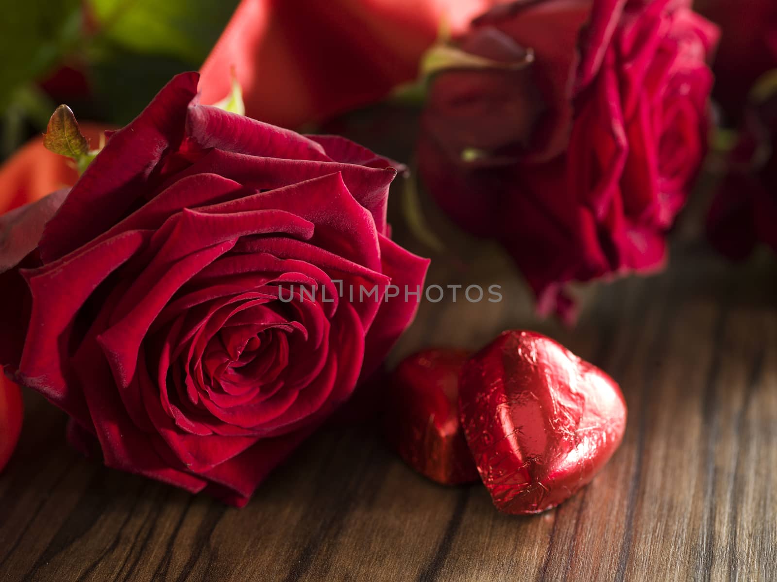 Chocolate hearts, red roses bouquet with red ribbon by janssenkruseproductions