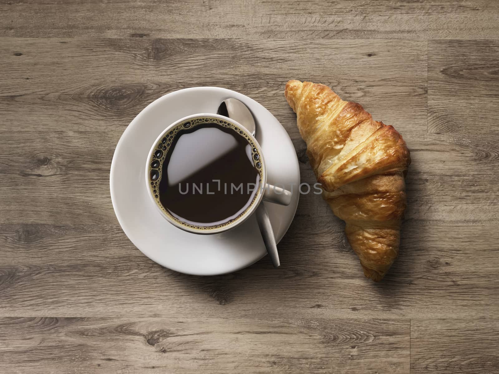 Coffee cup and fresh baked croissants on wooden background. Top View