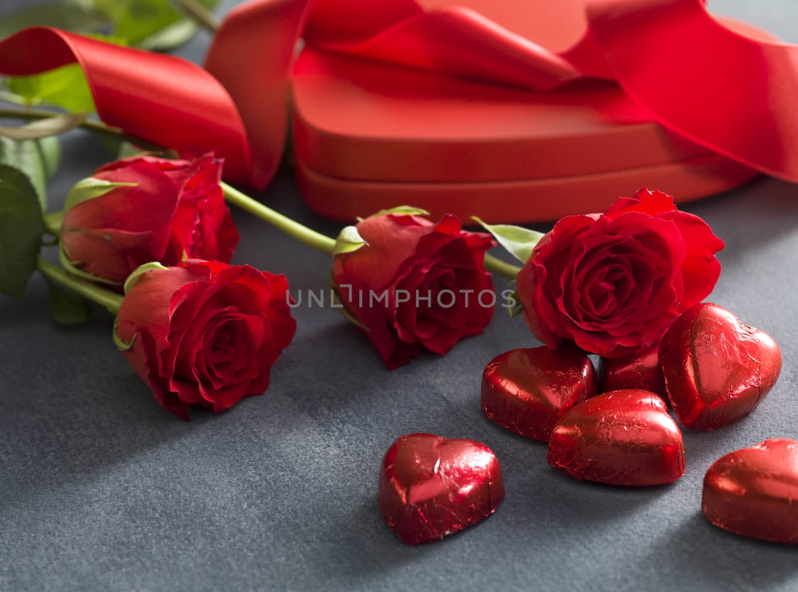 Gift box with red roses and chocolates on a grey background. Valentines Day concept