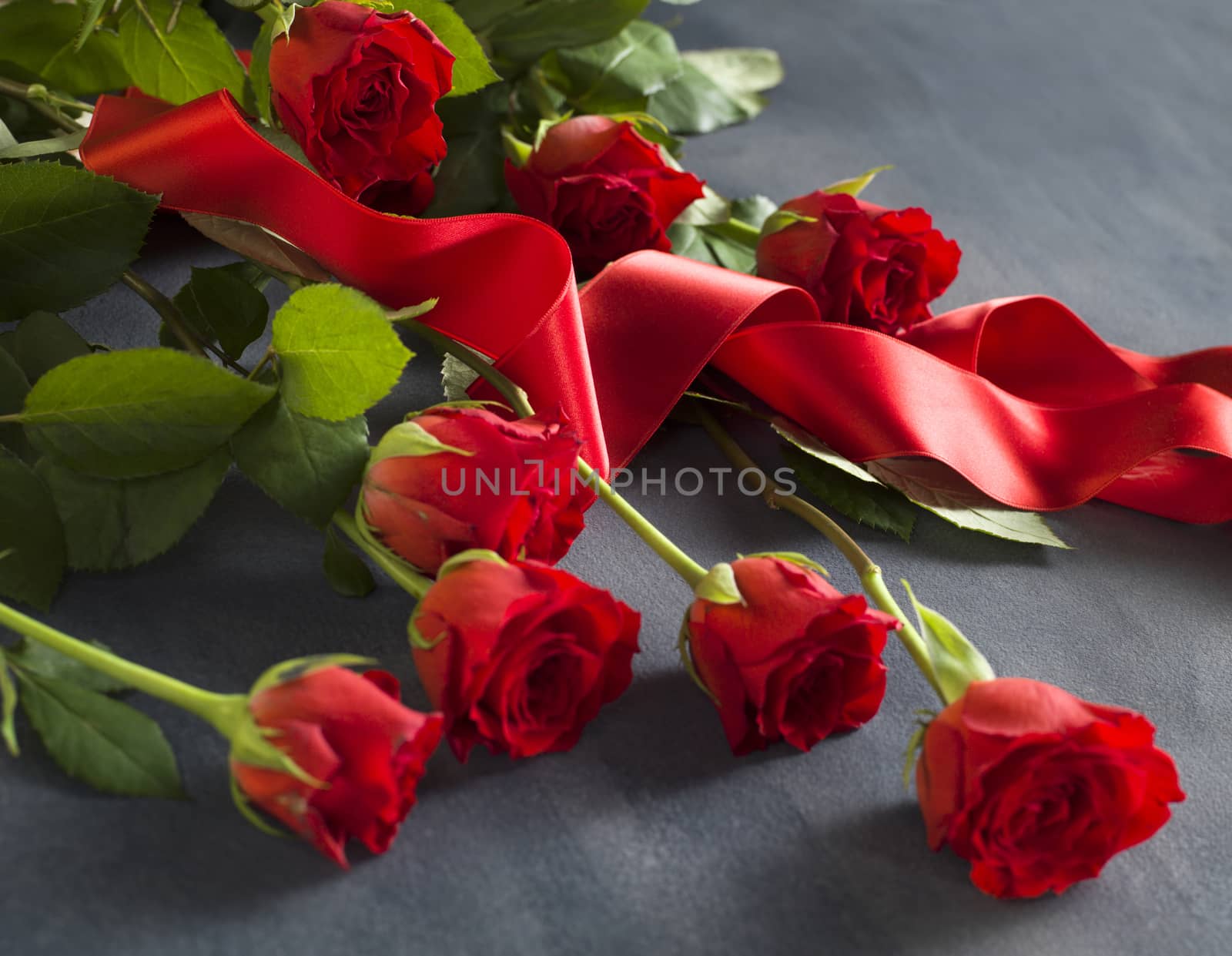 Grey stone with a bunch of red roses by janssenkruseproductions