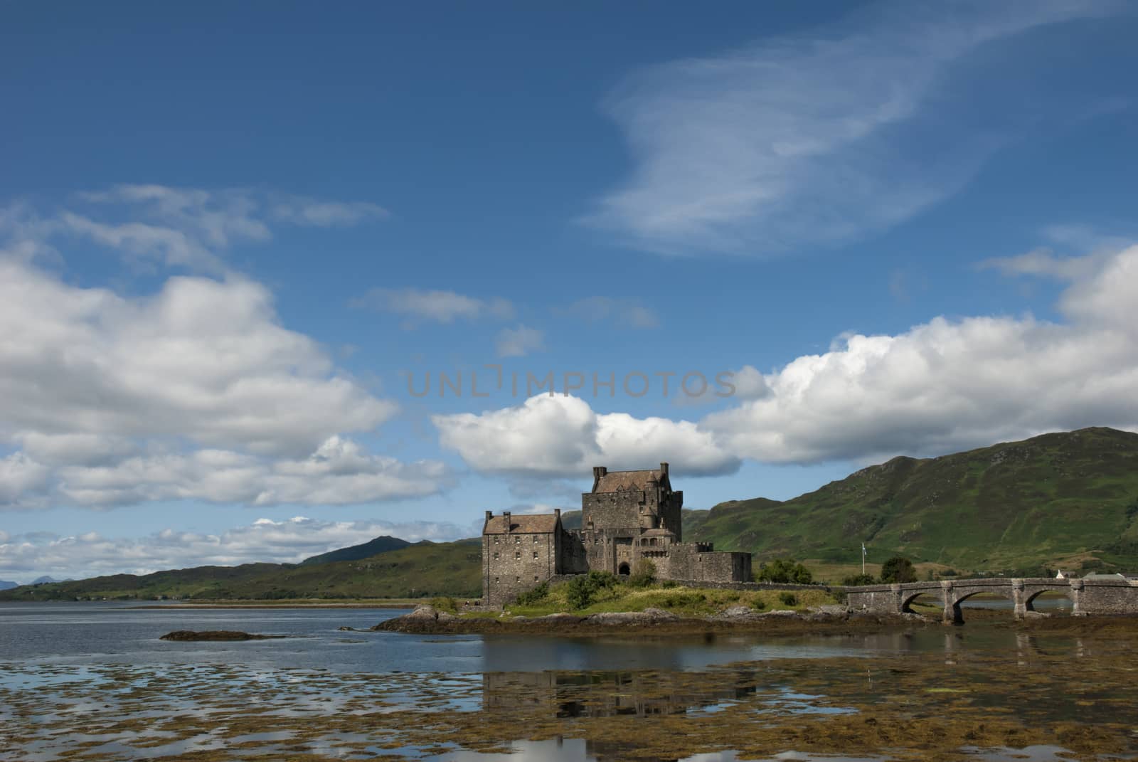 Majestic Eilean Donan castle on beautiful autumn day. with sunny foreground, dramatic sky and amazing scenery
