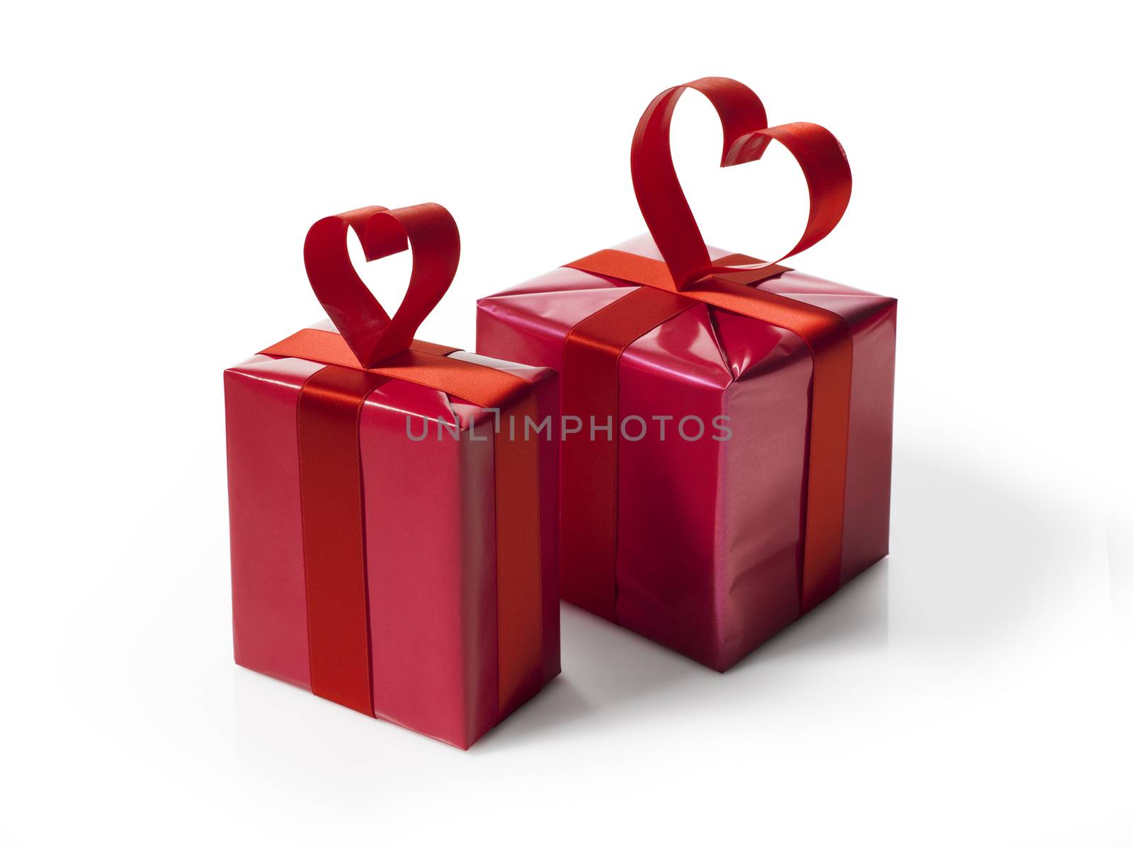 Red gift box with red hart shaped ribbon bow, isolated on white