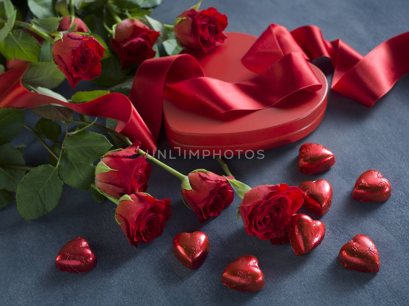 red hearts, ribbon and roses for valentines day on a grey background