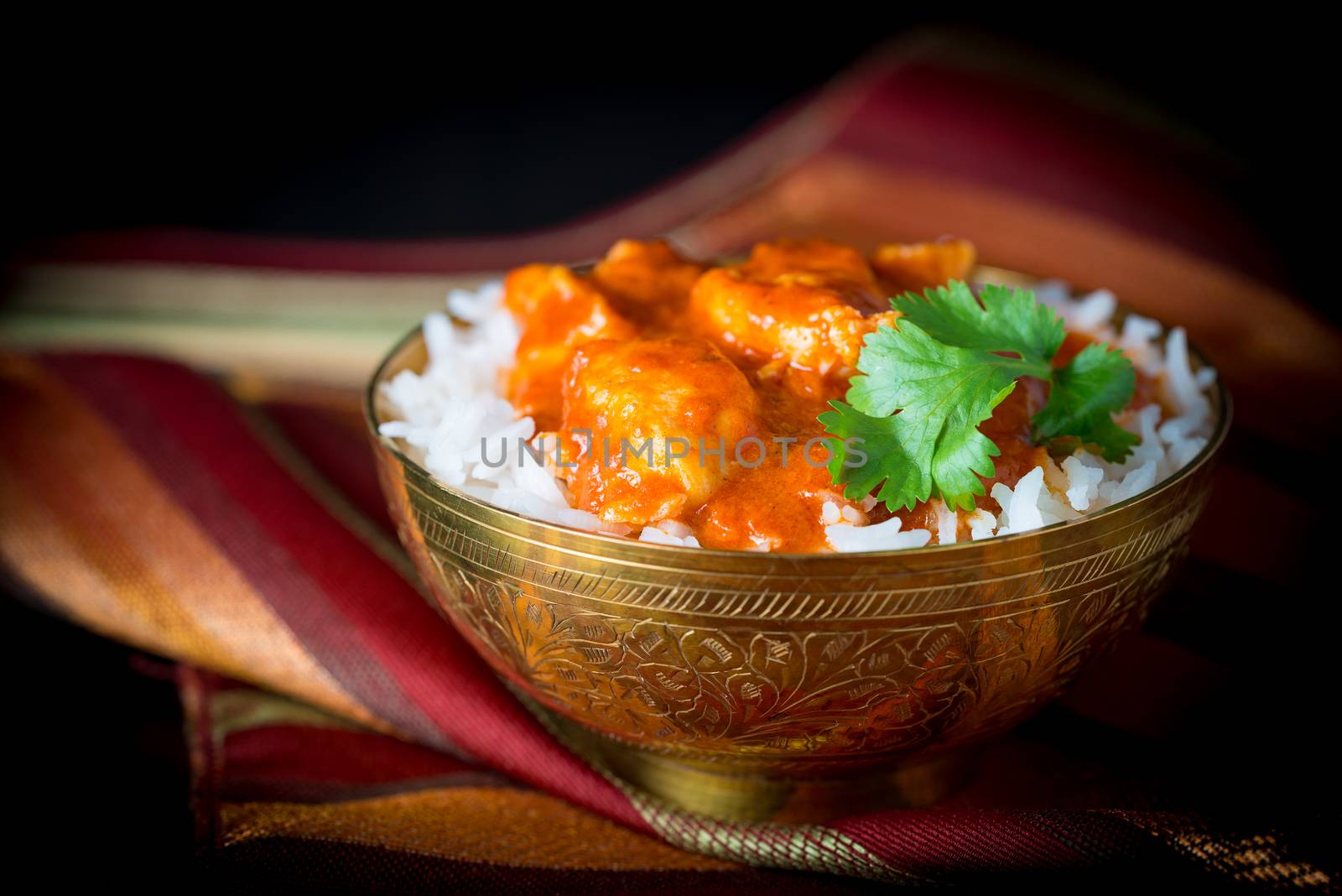 Bowl of butter chicken on a bed of basmati rice.