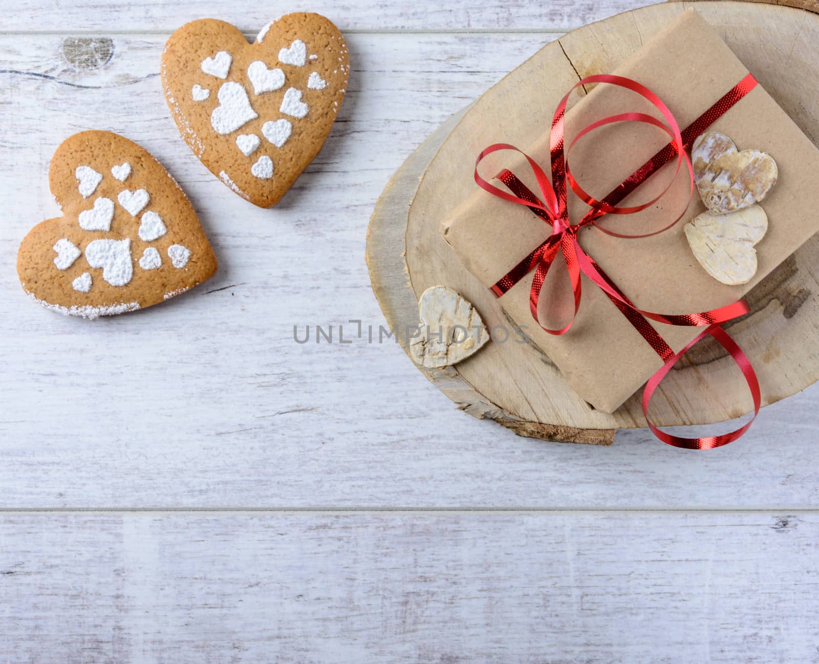 Box with a present to the Valentine's Day and cookies in the shape of heart lie on the white table