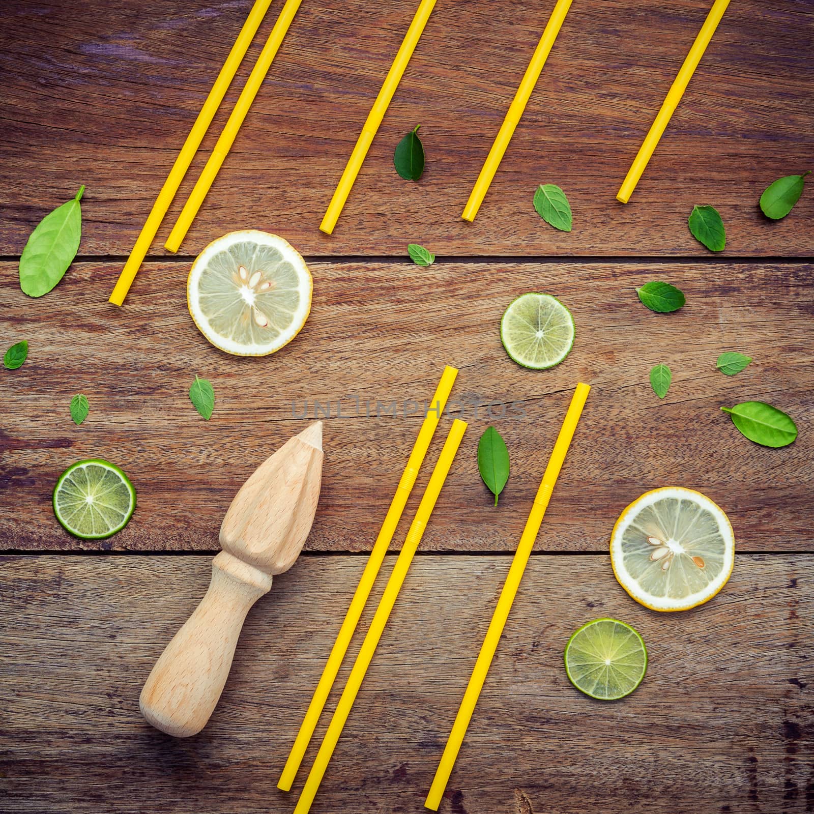 Fresh lemon and wooden juicer for summer juice and cocktail. Fresh lemon slices and peppermint leaves set up on shabby wooden background flat lay.