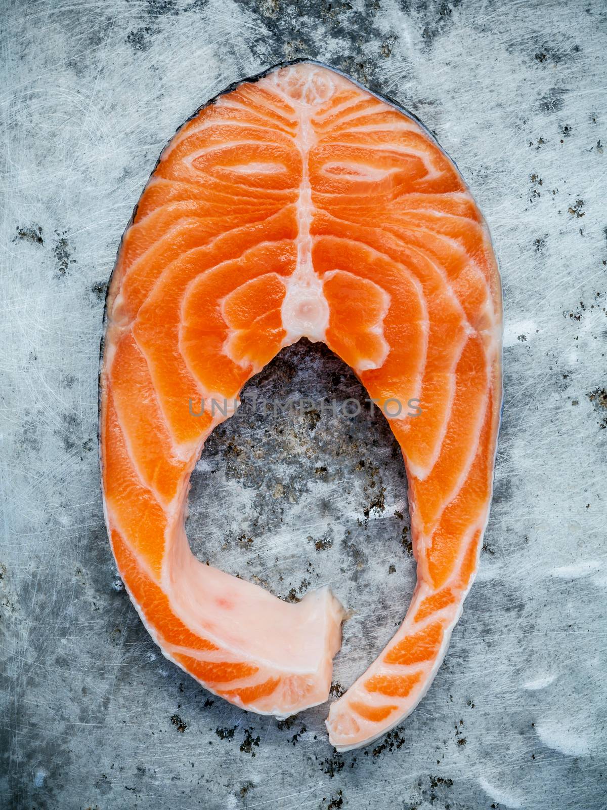 Closeup fresh salmon fillet sliced flat lay on shabby metal back by kerdkanno