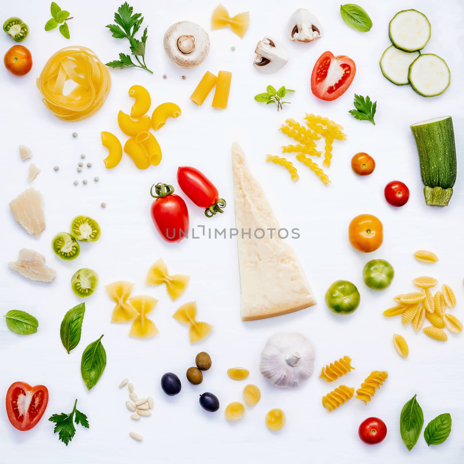 Italian food concept .Various kind of pasta with ingredients sweet basil ,tomato ,garlic ,parsley ,pine nut,pepper ,champignon ,zucchini and parmesan cheese on white wooden background flat lay.