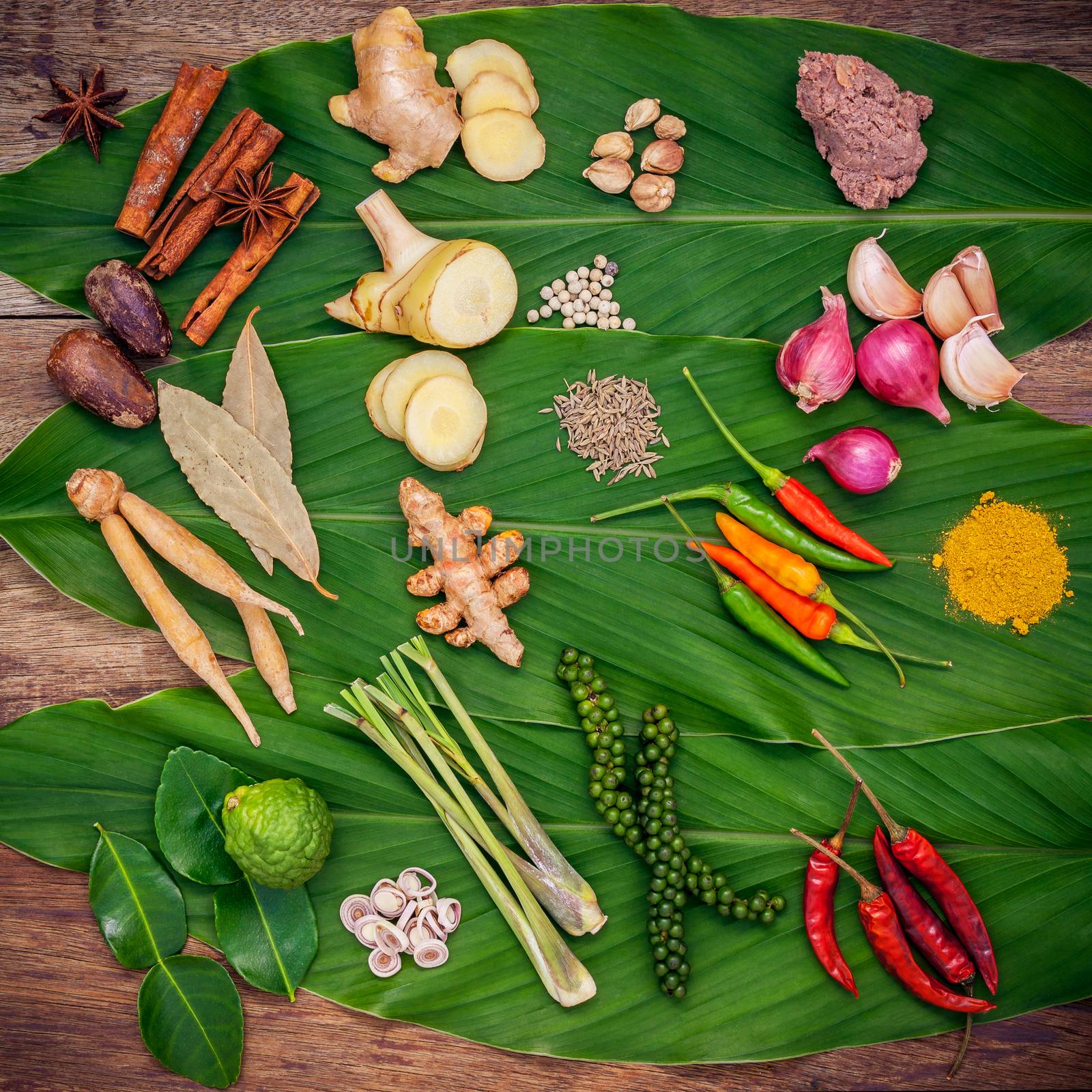 Various of Thai food Cooking ingredients and spice red curry paste ingredient of thai popular food on turmeric leaf background. Spices ingredients chili ,pepper, nutmeg, garlic and Kaffir lime leaves.