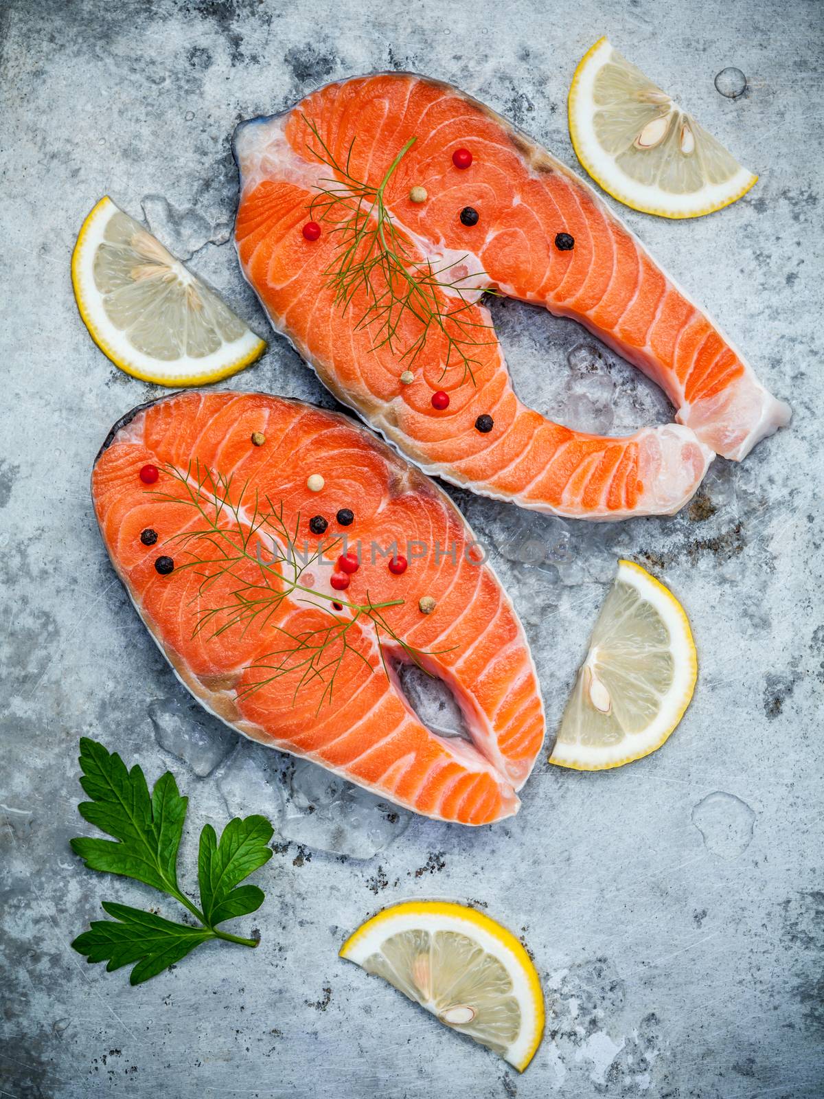 Fresh salmon fillet sliced flat lay on shabby metal background. Raw salmon fillet and ingredients parsley ,sweet basil leaves ,fennel ,pepper corn and lemon for cooking.