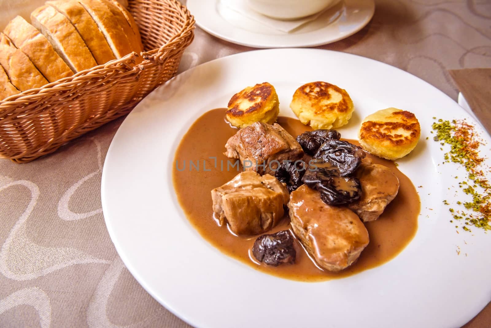 Slovenian dish from Ljubljana, delicious pork meat with plum brandy sauce and dried plums, and baked dodole as a side dish, called Zganjarsko.