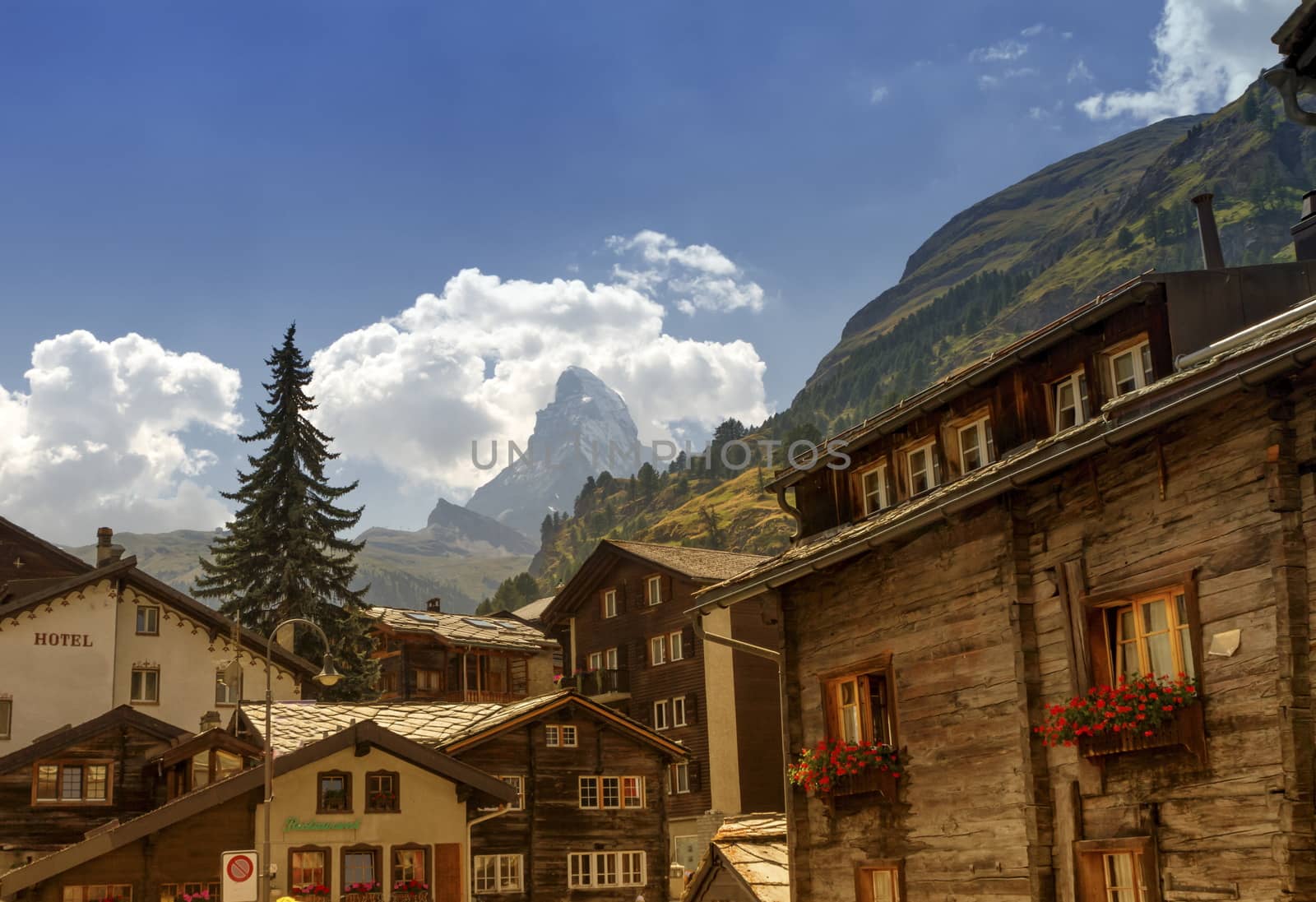 Matterhorn surrounded with clouds in front of Zermatt village houses by day, Zermatt, Switzerland