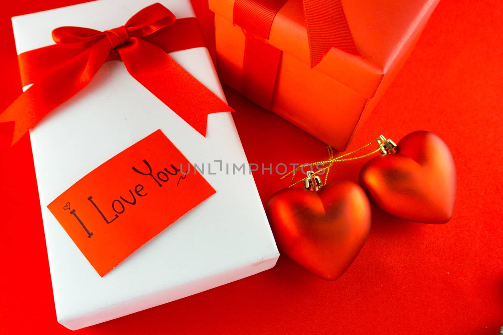 Valentines gift box with a red bow on red background. Image of Valentines day.
