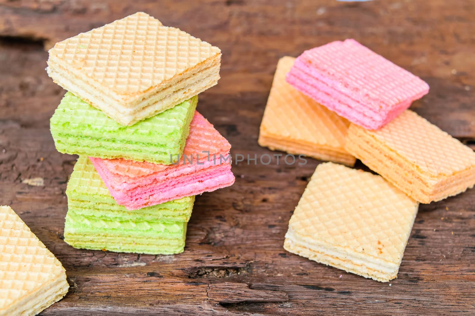Colorful candy wafers on a wooden table.