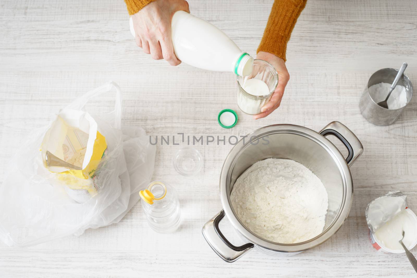 Woman prepares dough pizza on the white table horizontal