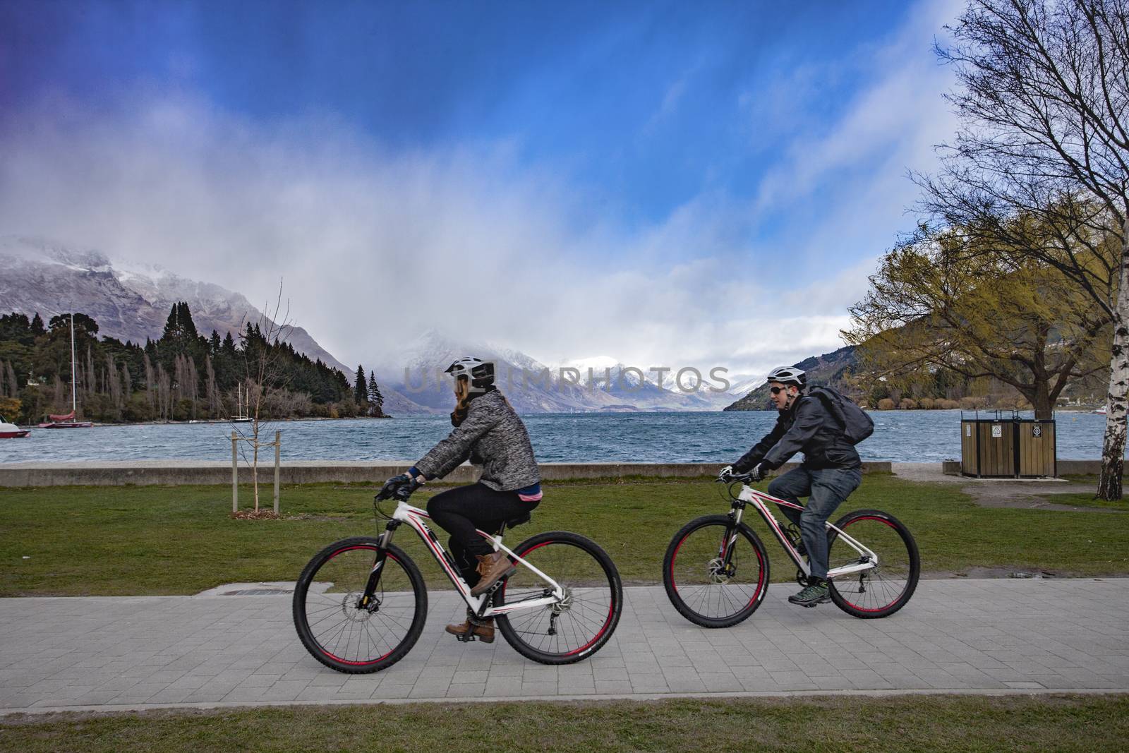QUEENSTOWN NEW ZEALAND - SEPTEMBER 6 :  tourist riding bicycle around lake wakatipu important traveling destination in south island on september 6 , 2015 in queenstown new zealand