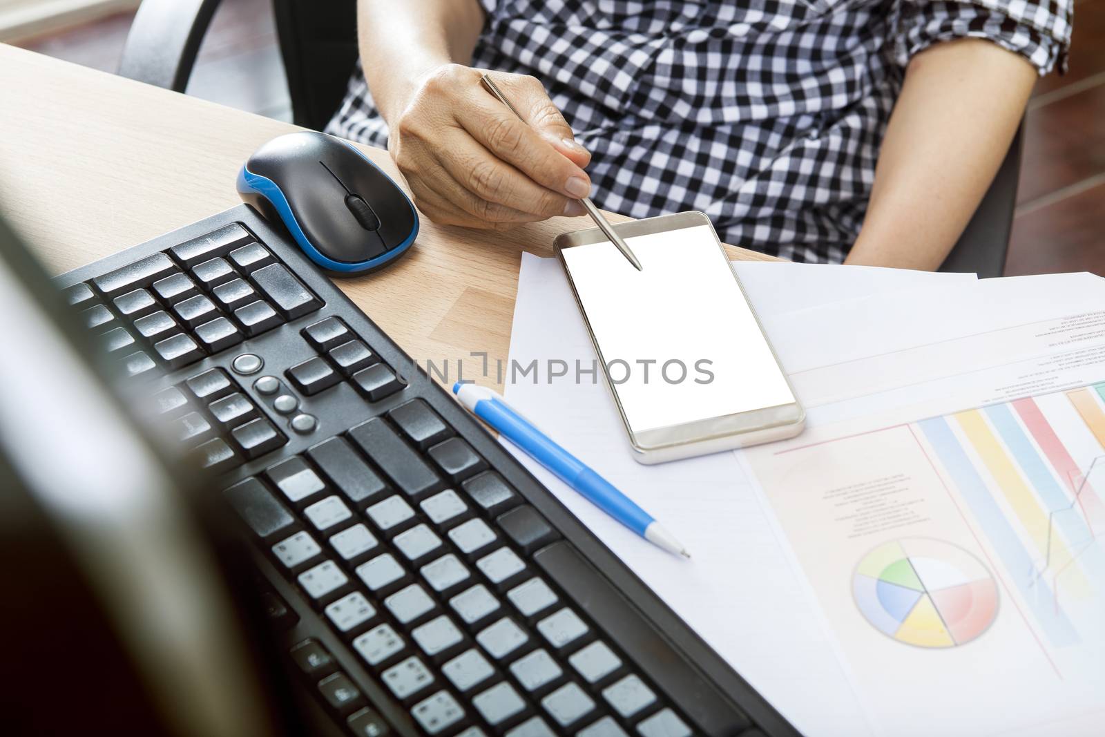 working woman using smart phone reading message on screen ,on office table shot