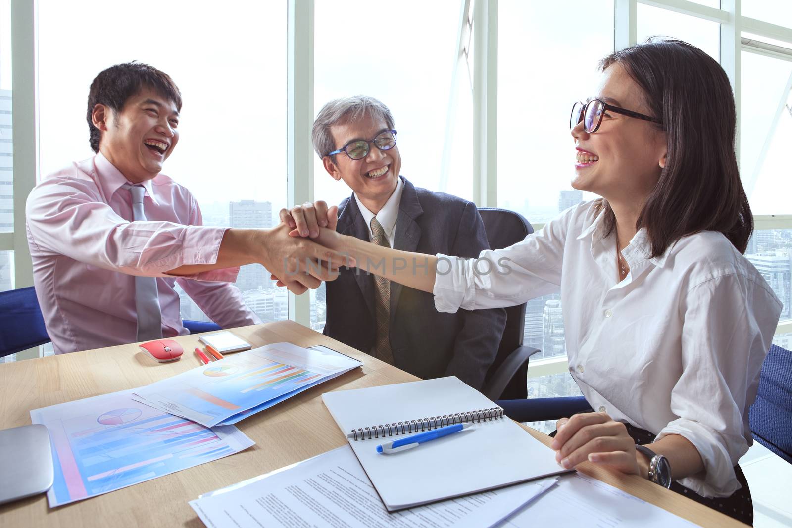 business team shaking hand and laughing happiness for successful working project