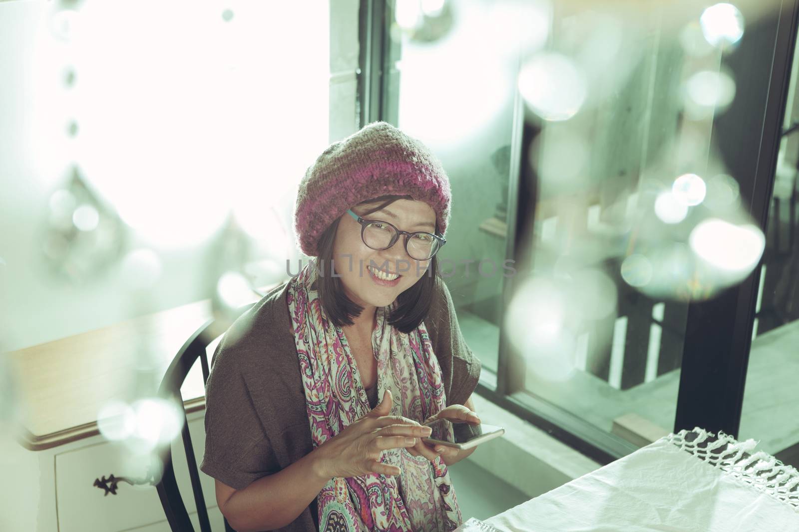 asian woman and smart phone in hand with smiling face happiness  by khunaspix