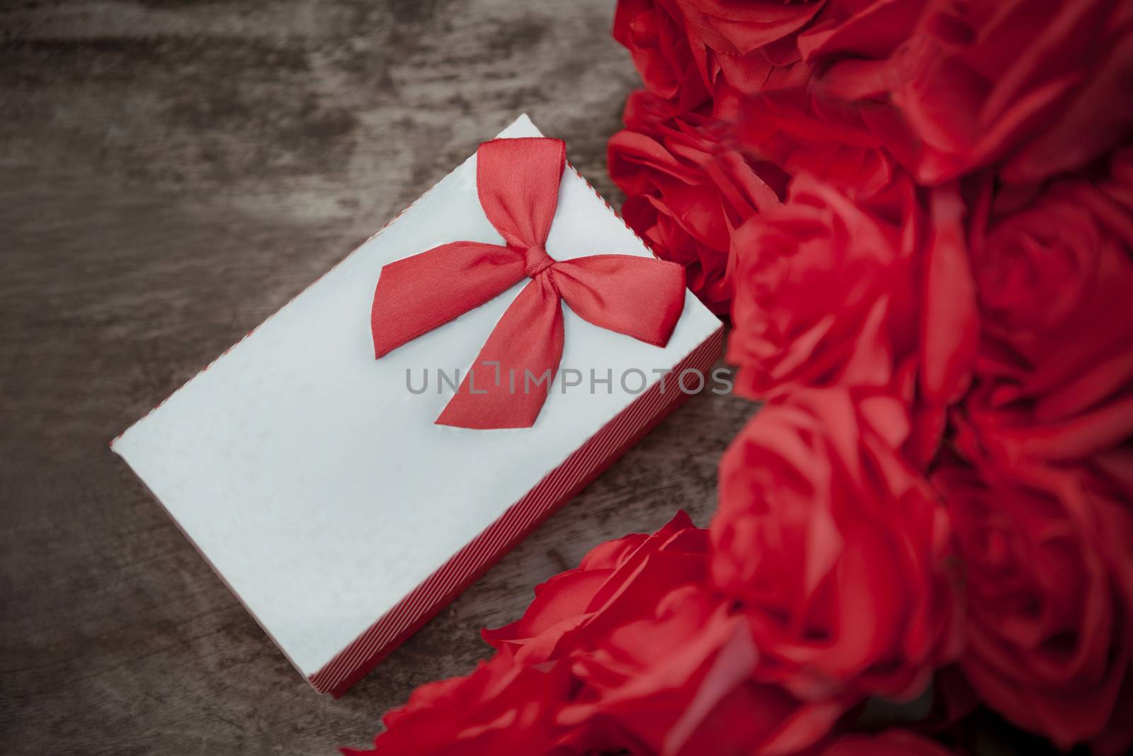 valentine gift box on wood table with red roses bouquet for love and happiness theme
