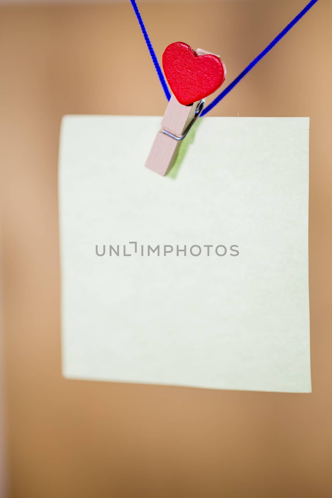 Heart clothes peg holding note with blank copy space