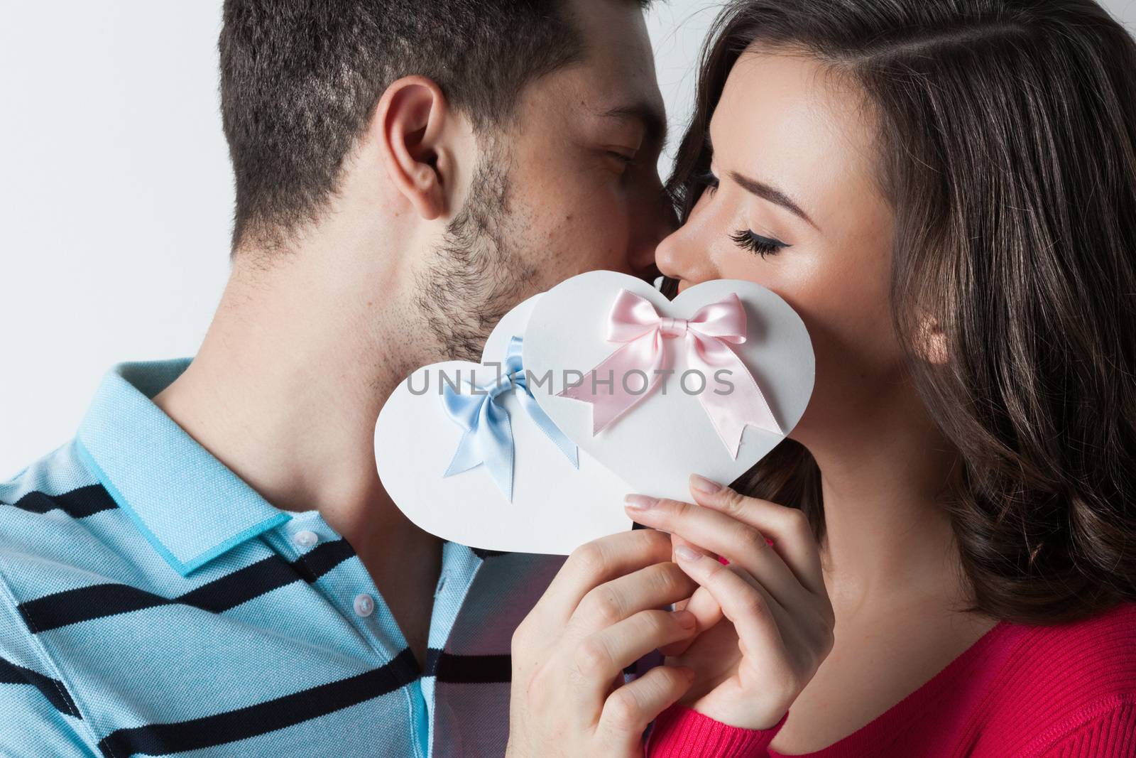 Young couple celebrating Valentine day holding paper heart cards
