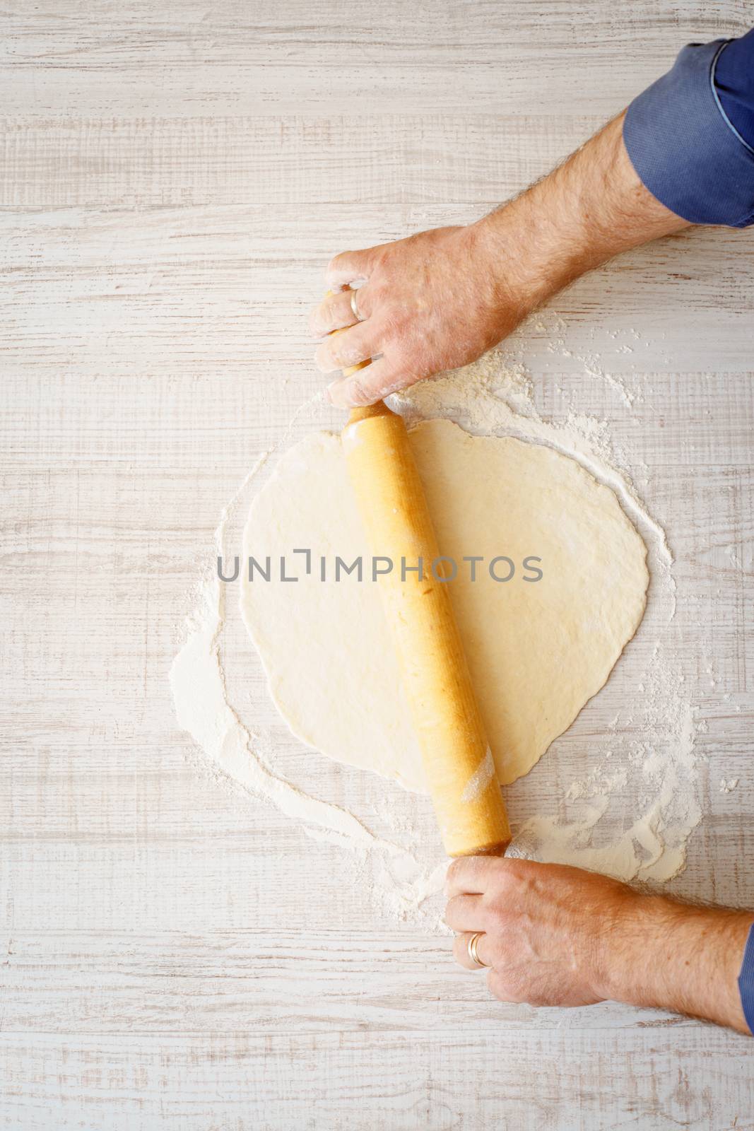 Rolling dough on the white table by Deniskarpenkov
