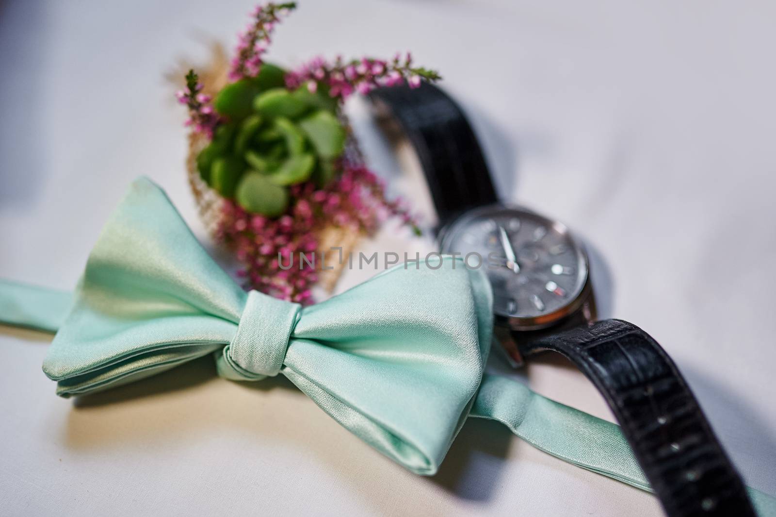 man watches and turquoise Butterfly on table.