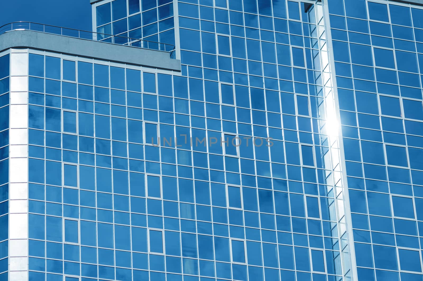 blue glass office building with windows reflected sky