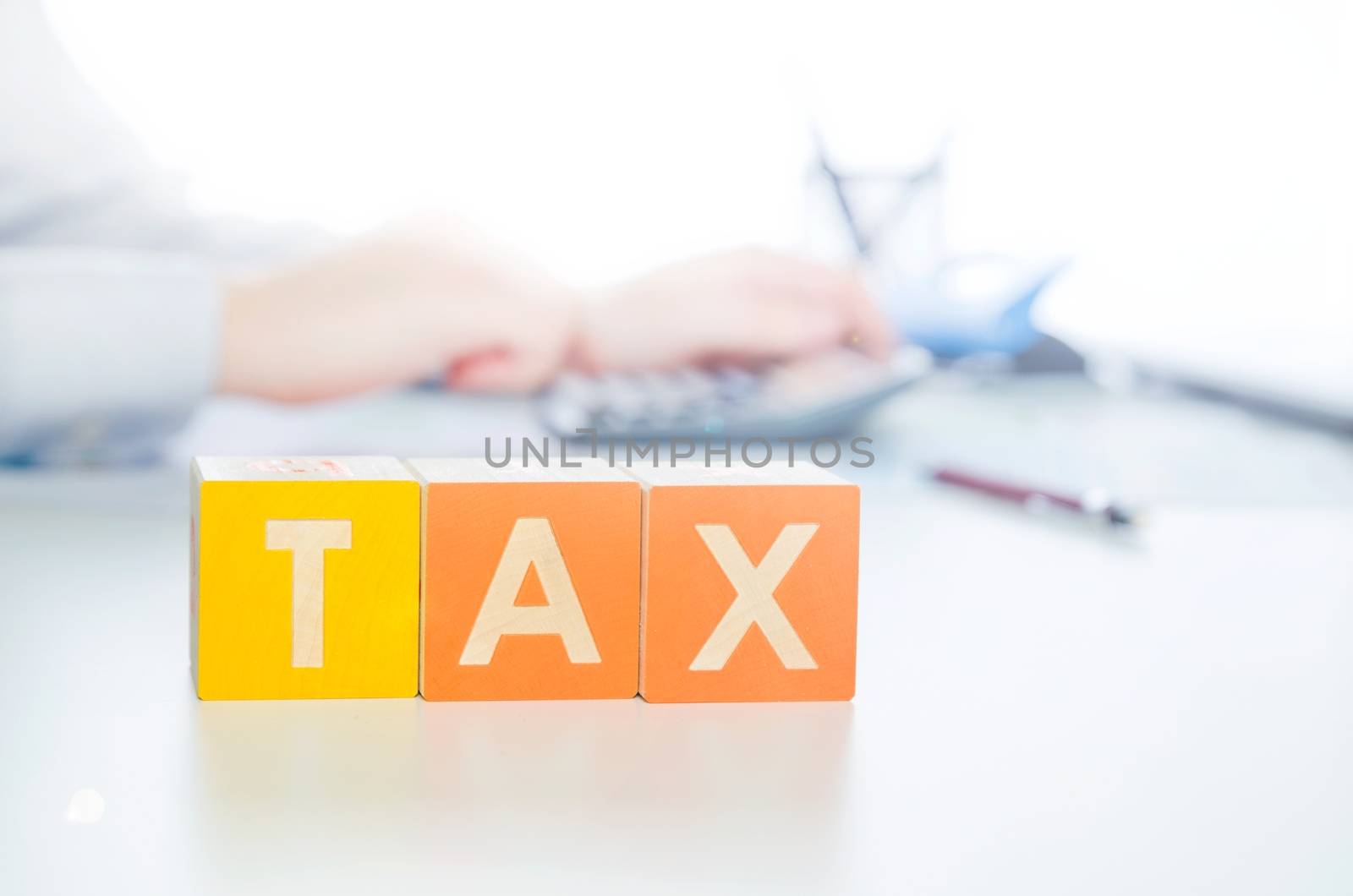 Tax word with colorful blocks. tax money business finance cost block businessman in background concept