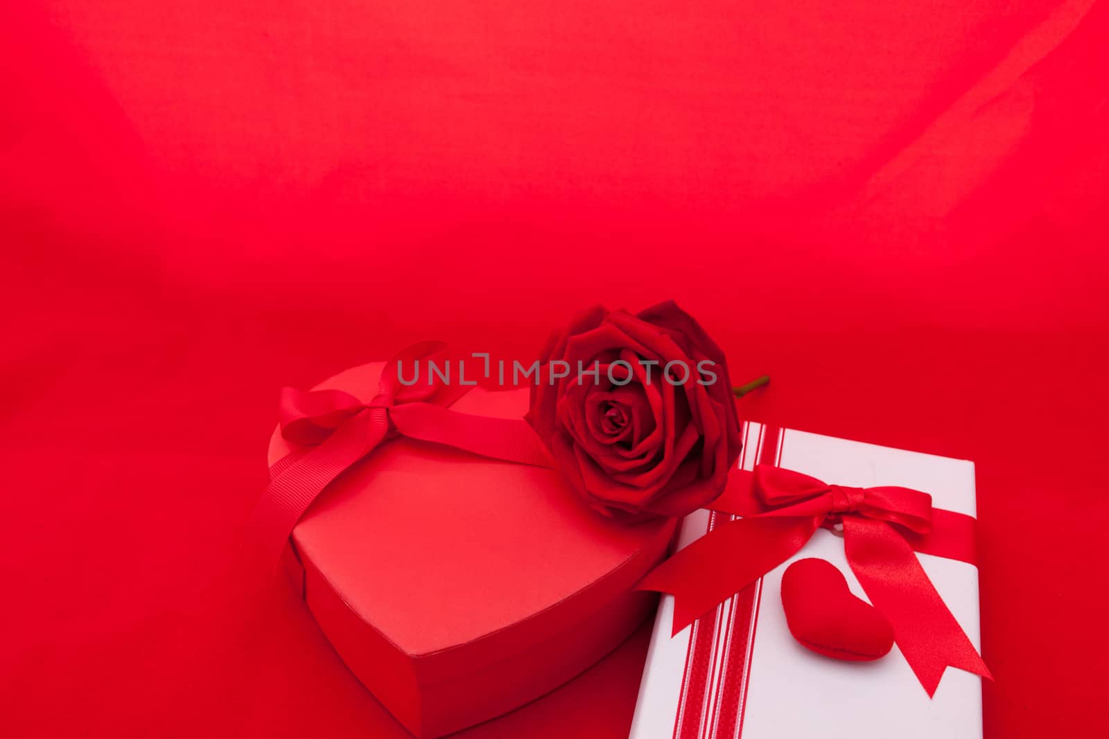 Valentines gift box with a red bow on red background. Image of Valentines day.