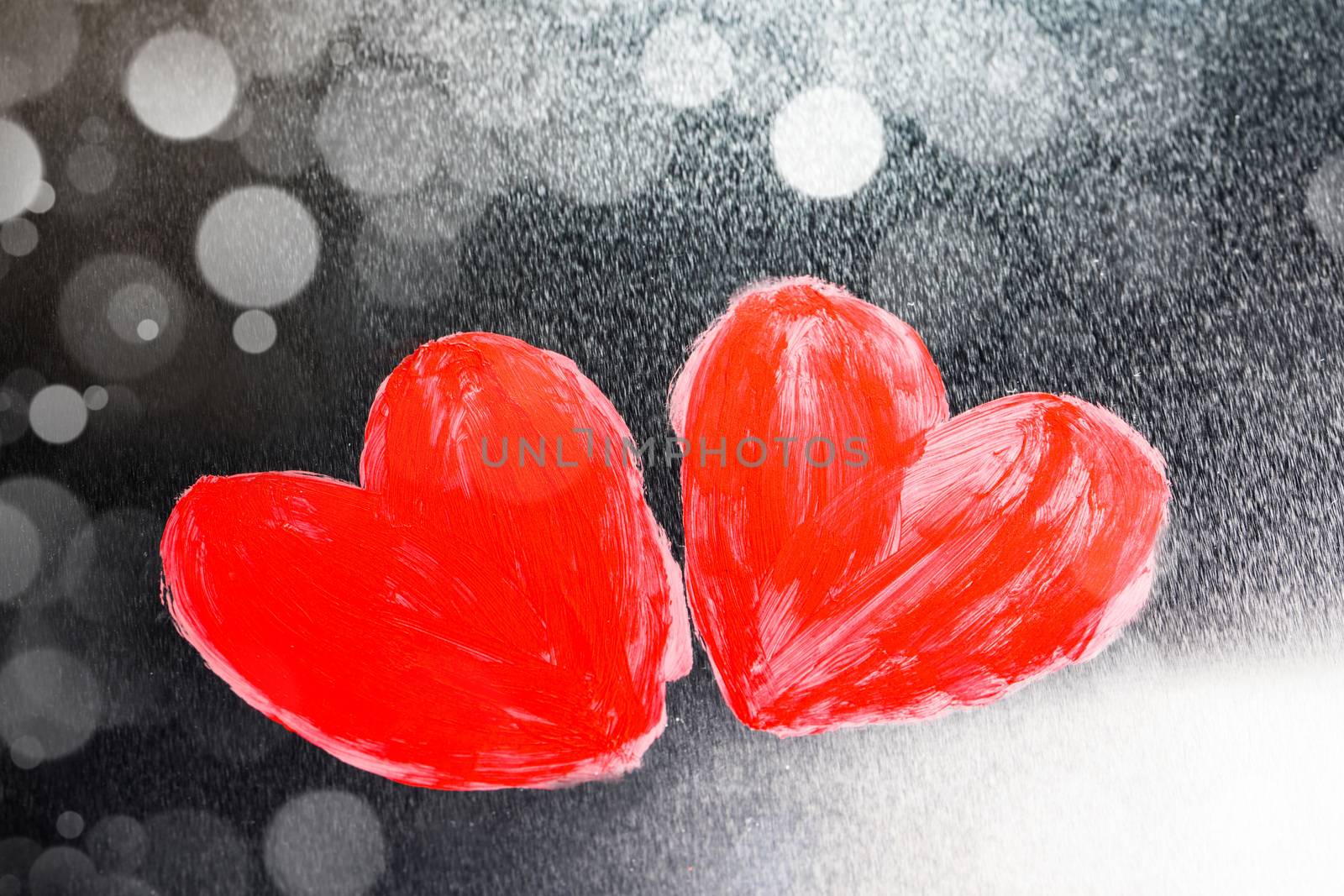 Two abstract red painted hearts on metal background