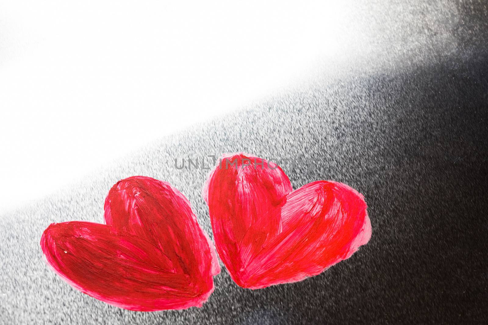 Two abstract red painted hearts on metal background