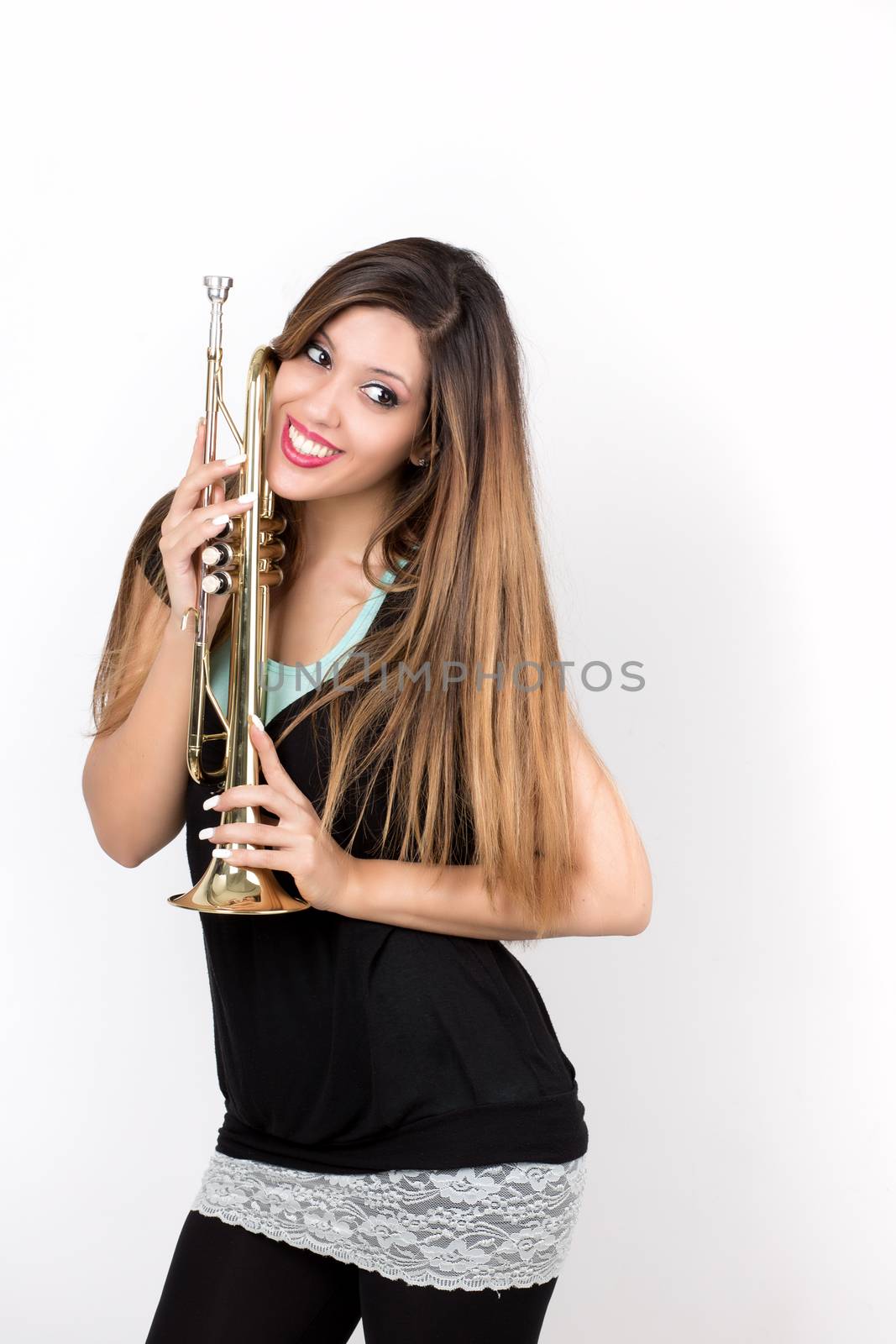 Funny beautiful woman smiling holding trumpet isolated