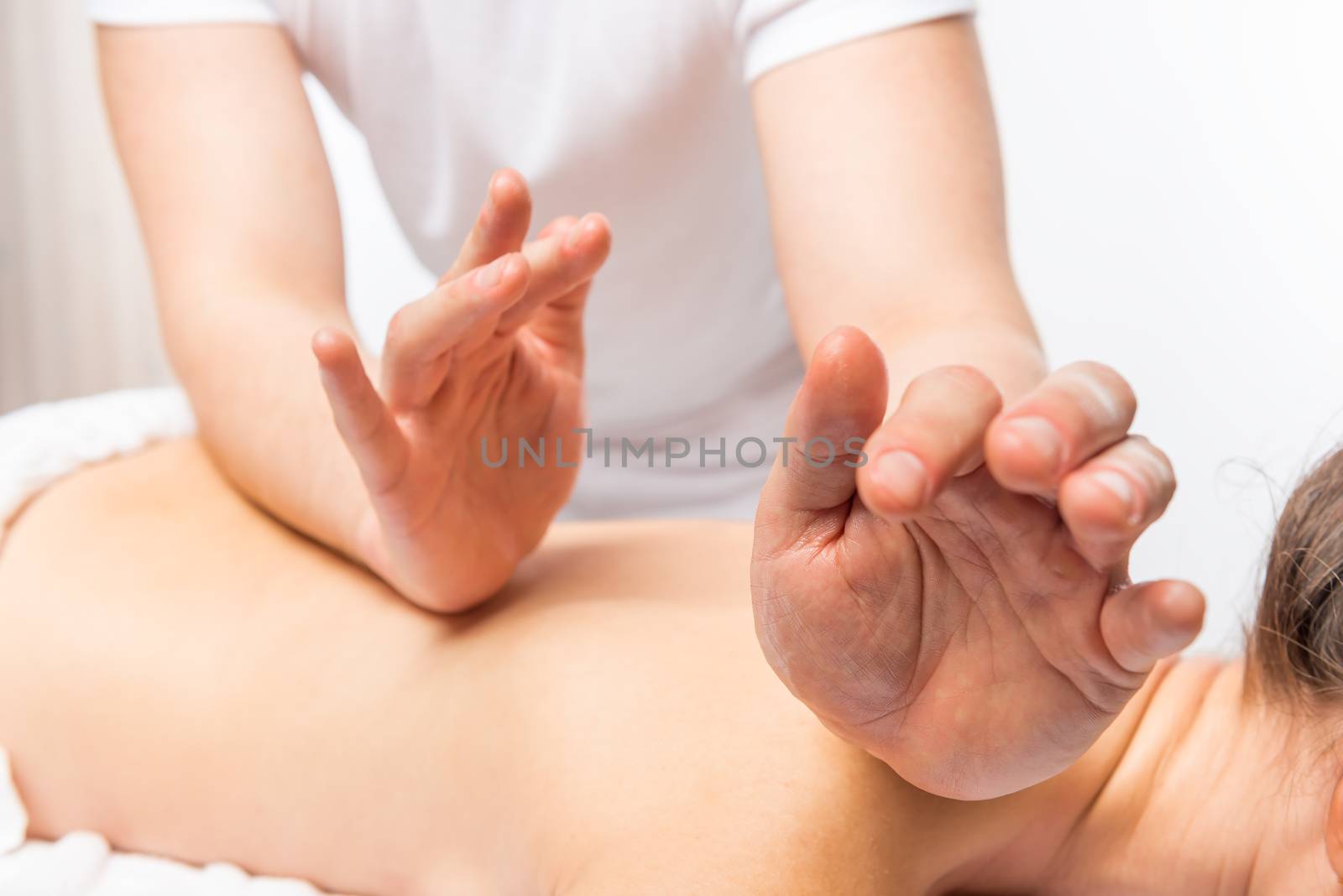 professional masseur doing massage a girl the back