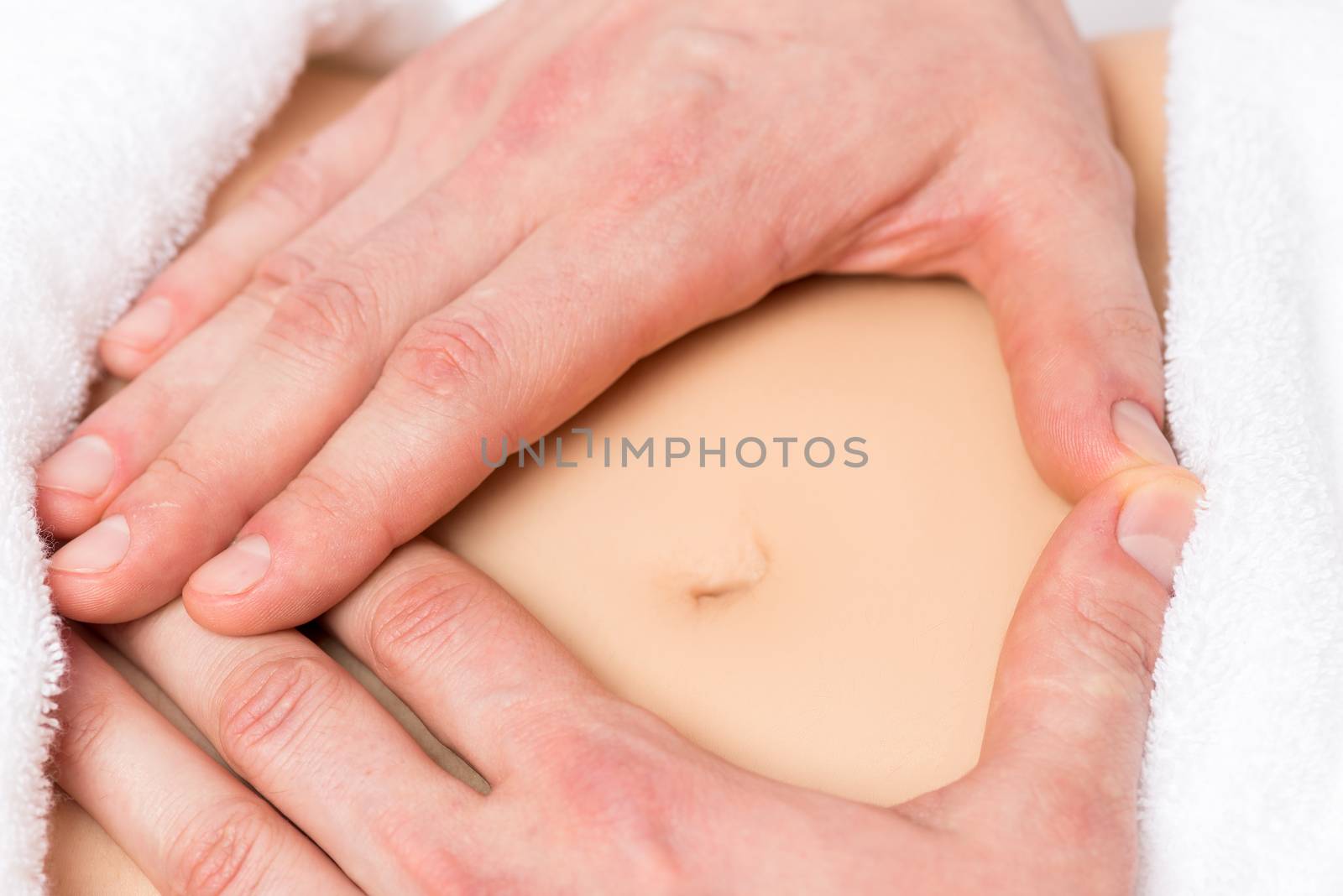 male hands in a heart shape on the abdomen of a pregnant woman close-up