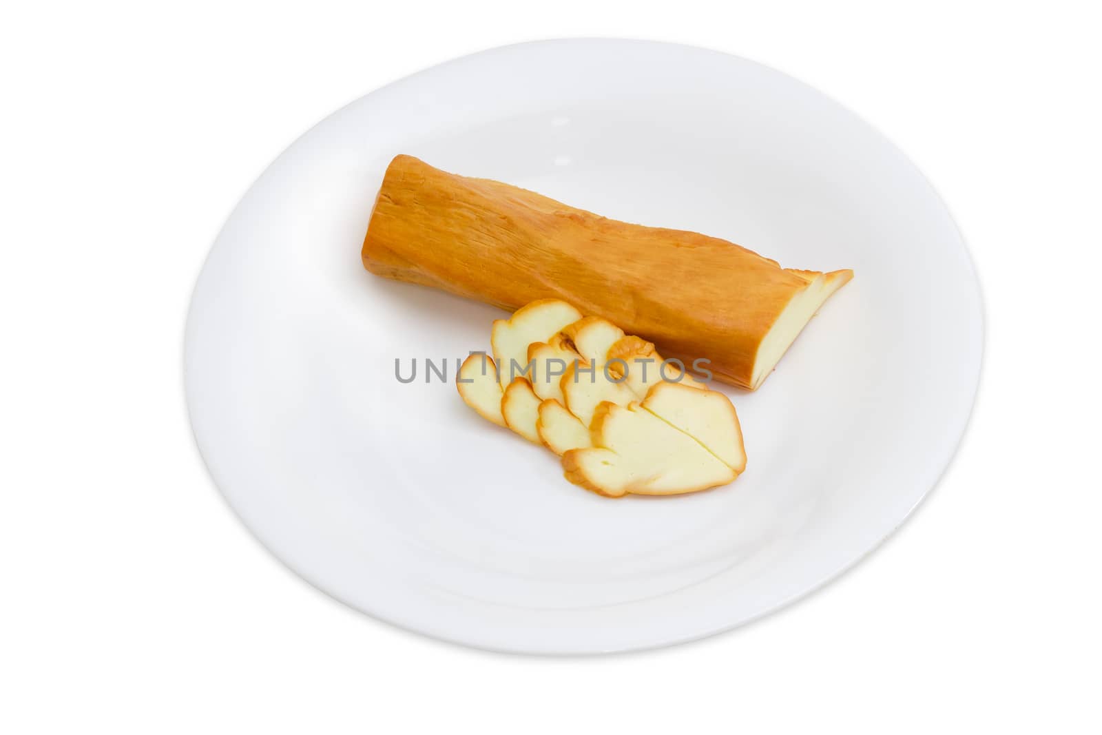 Part of a stick smoked chechil cheese and several slices on a white dish on a light background

